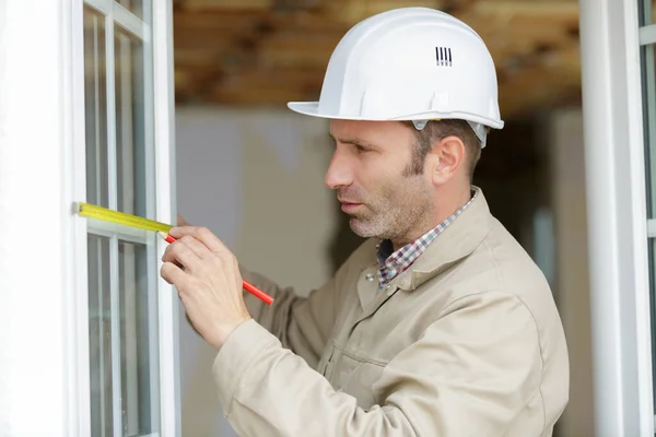 Builder Pomiar Okna Pomocą Taśmy Mierniczej Ołówek — Zdjęcie stockowe