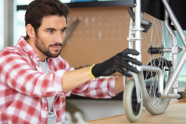 Muž Udržuje Invalidní Vozík Postavený Lavičce — Stock fotografie