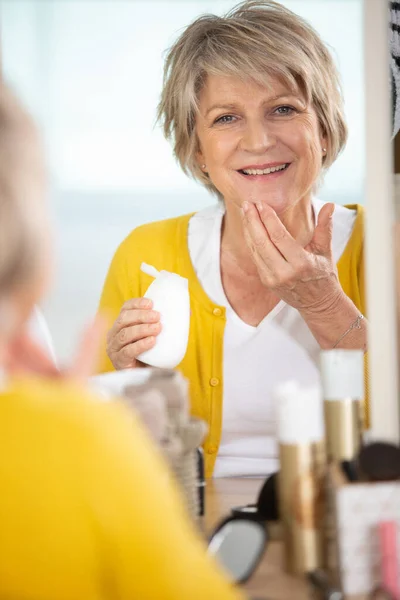 Donna Anziana Sorridente Che Applica Lozione Invecchiamento — Foto Stock