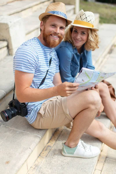 地図を観察し 彼らの休暇を議論する幸せなカップル — ストック写真