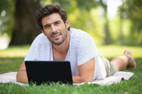 Mann Legt Sich Ins Gras Und Arbeitet Mit Tablet — Stockfoto