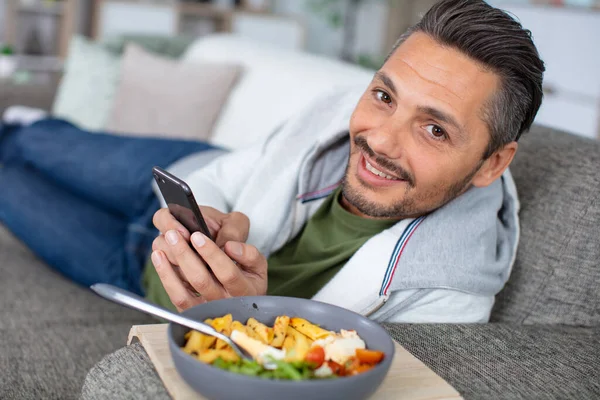 Hombre Comiendo Una Ensalada Sofá —  Fotos de Stock