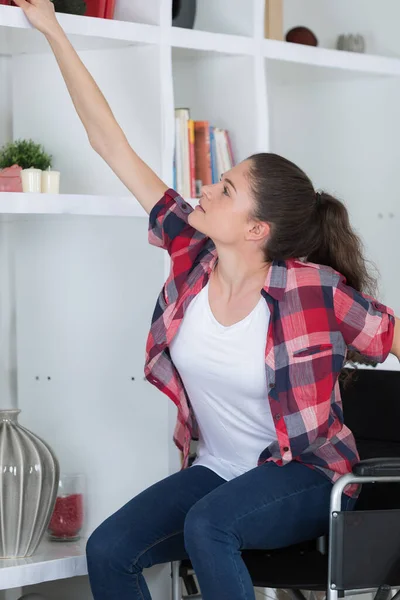 Vrouw Rolstoel Reikt Naar Iets Woonkamer — Stockfoto