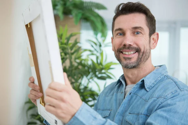 Man Hanging Picture Home — Stock Photo, Image