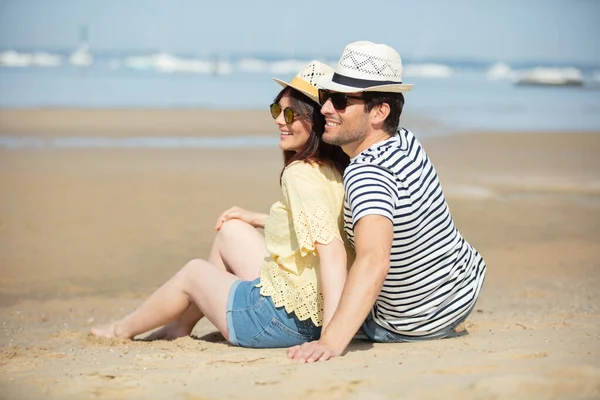 幸せなカップルが一緒にビーチで抱き合って笑っています — ストック写真