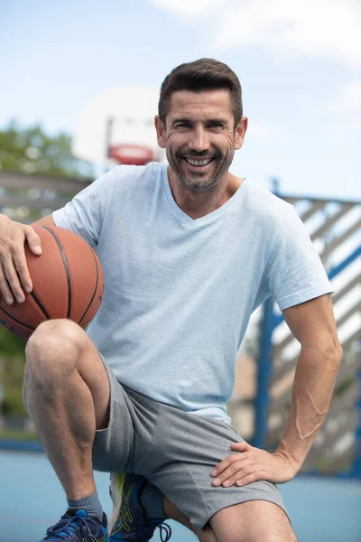 Ritratto Uomo Mezza Età Accovacciato Con Mano Pallone Basket — Foto Stock