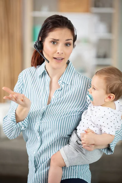 Multitarefa Empresária Trabalhando Com Fone Ouvido Com Seu Bebê — Fotografia de Stock