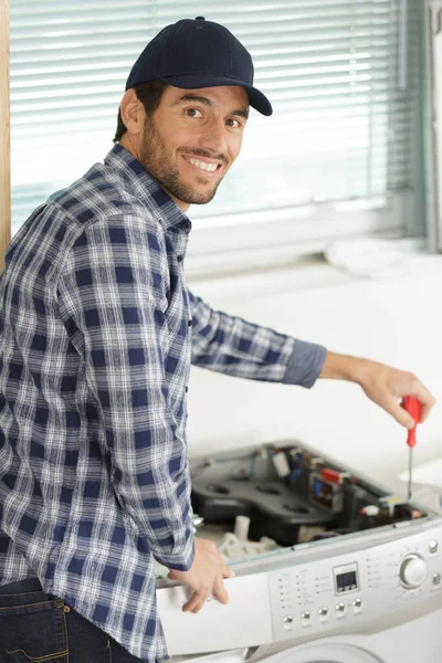 Happy Working Man Plumber Repairs Washing Machine — Stock Photo, Image