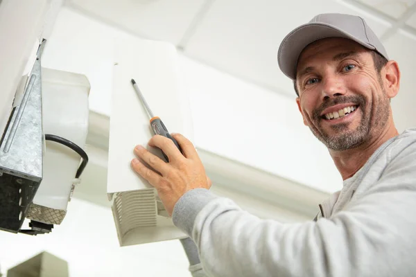 壁に電気機器を設置する男性電気技師は — ストック写真