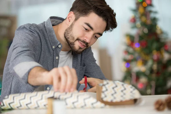Jonge Man Inpakken Geschenken Het Maken Van Boog Tafel — Stockfoto
