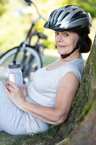 Ciclista Sênior Feminino Relaxando Contra Uma Árvore — Fotografia de Stock