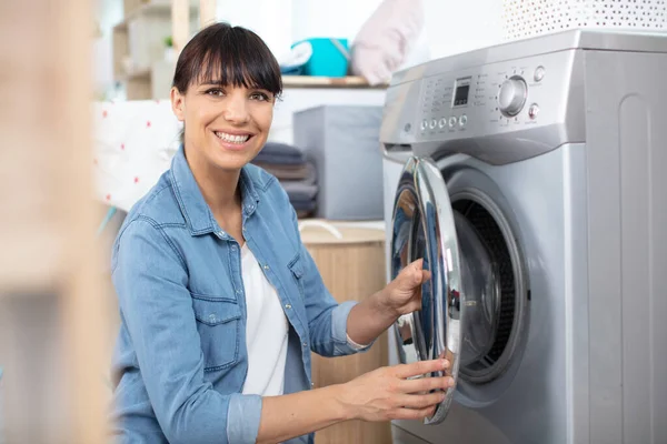 女人在洗衣机里装脏衣服 — 图库照片