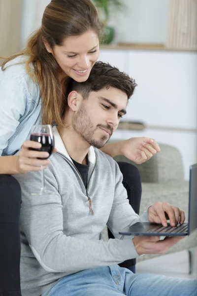 自宅でノートパソコンを見ている若いカップルは — ストック写真