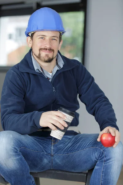 Ung Man Byggnadsarbetare Som Håller Ett Äpple — Stockfoto