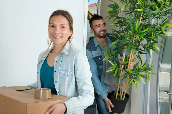 Jeune Couple Portant Leurs Effets Personnels Compris Plante — Photo