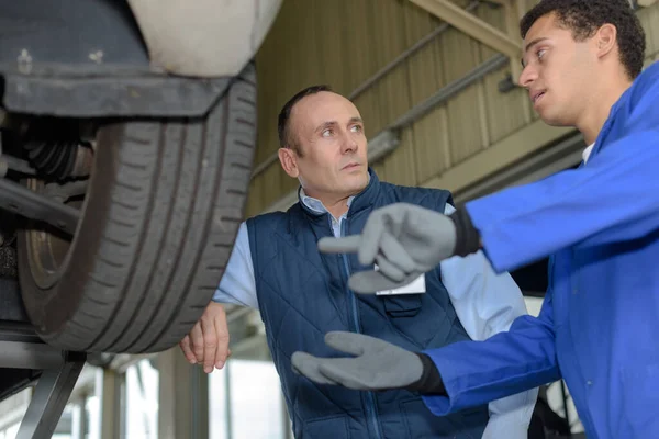 Meccanico Ponendo Supervisore Una Domanda Sulla Ruota Dell Auto — Foto Stock