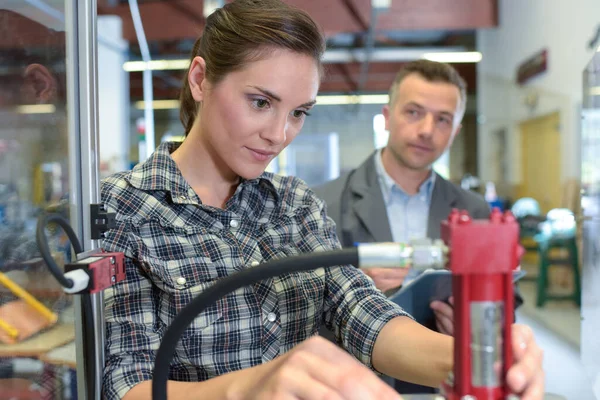 Foreman Observera Kvinnliga Arbetstagare Med Hjälp Hydraulisk Utrustning — Stockfoto