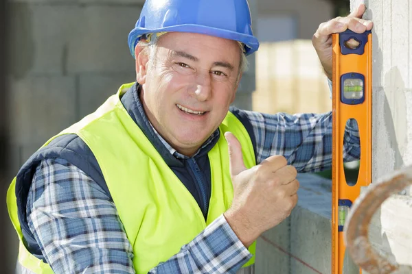 Bauarbeiter Mit Wasserwaage Baustellenwand — Stockfoto