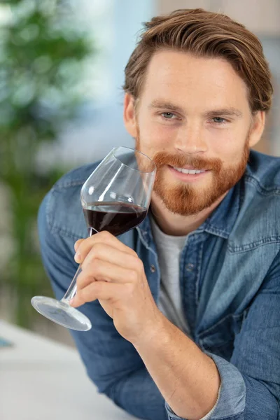 Stilig Ung Man Luktar Rött Vin Innan Han Dricker Det — Stockfoto