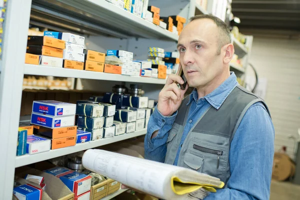 フォルダを保持し 電話で話す店の男 — ストック写真