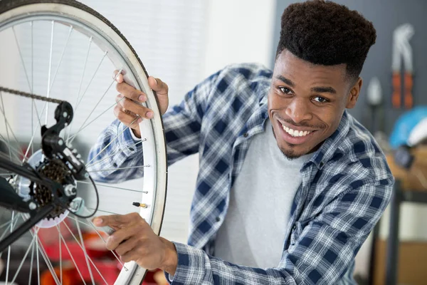 自行车轮子上使用扳手的男性技师 — 图库照片
