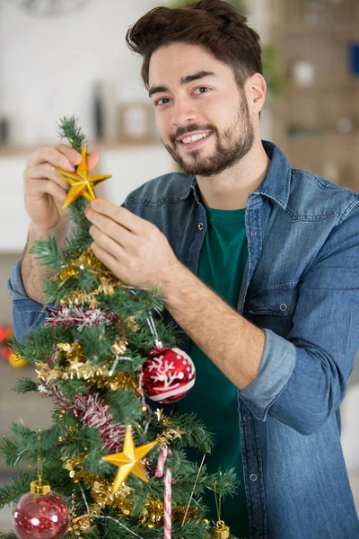 Веселый Молодой Человек Вешает Рождественскую Звезду — стоковое фото