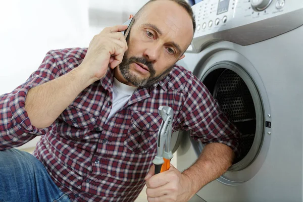 Άνθρωπος Στο Τηλέφωνο Προβλήματα Πλυντήριο Ρούχων — Φωτογραφία Αρχείου