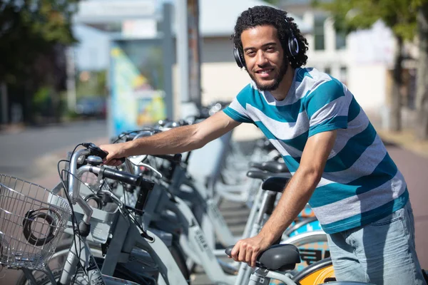 Man Met Koptelefoon Parkeren Huurfiets — Stockfoto