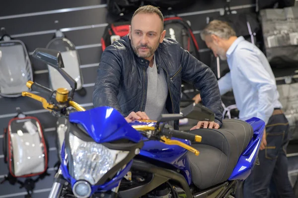 Mężczyzna Patrząc Czule Motocykl Salonie — Zdjęcie stockowe