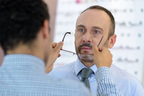 Young Male Optician Fitting Glasses Mature Male Customer — Stock Photo, Image