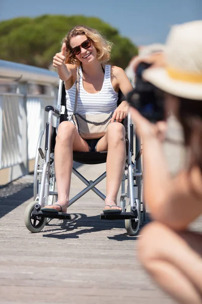 轮椅上的妇女举着大拇指拍照 — 图库照片