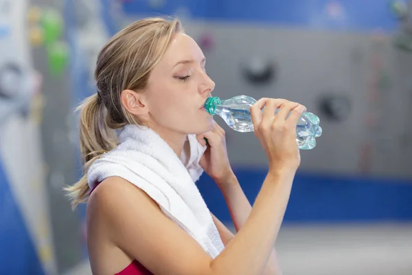 安静時の美しい若い女性とジムで水を飲む — ストック写真