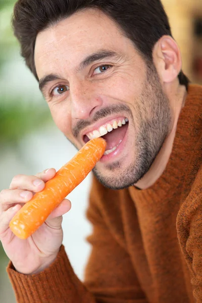 Junger Mann Ißt Eine Karotte — Stockfoto