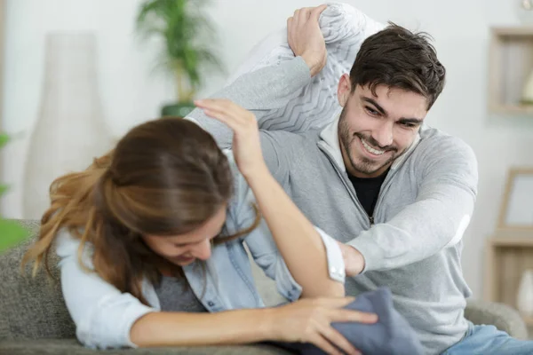 Divertida Pareja Sentados Juntos Sofá Luchando Con Almohadas —  Fotos de Stock