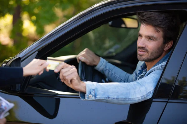 Serious Man Giving Credit Card While Sitting His Car — Stock Photo, Image