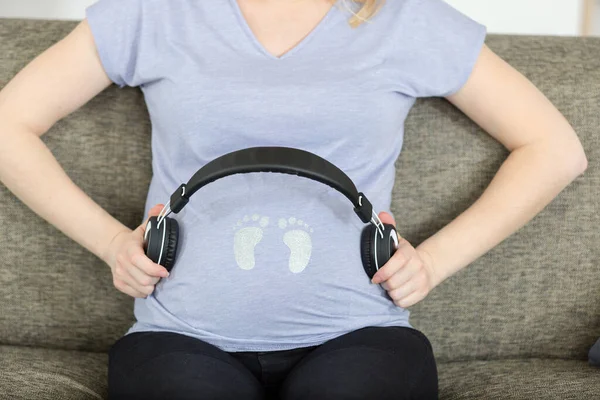 Schwangere Setzt Kopfhörer Auf Bauch — Stockfoto