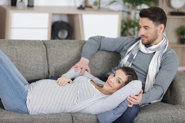 Happy Man Touching Smiling Pregnant Woman Lying Sofa — Stock Photo, Image