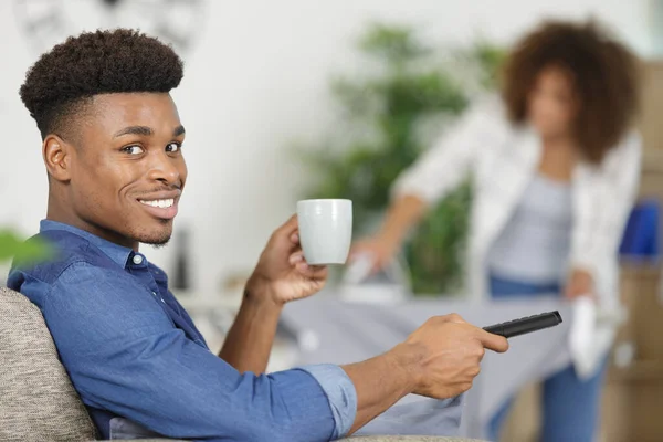 女朋友工作时 沙发上坐着喝茶的男人 — 图库照片