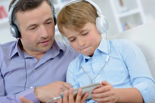 Man Och Pojke Bär Hörlurar Tittar Elektronisk Utrustning — Stockfoto