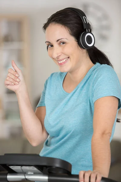 Frau Hört Musik Während Sie Trainingsgerät Benutzt — Stockfoto