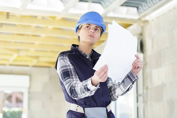 Kvinnlig Byggnadsingenjör Kontrollerar Ritningen — Stockfoto