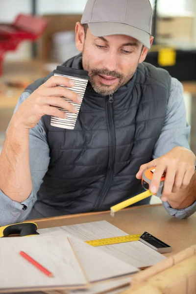 Uomo Banco Lavoro Con Tazza Metro Nastro — Foto Stock