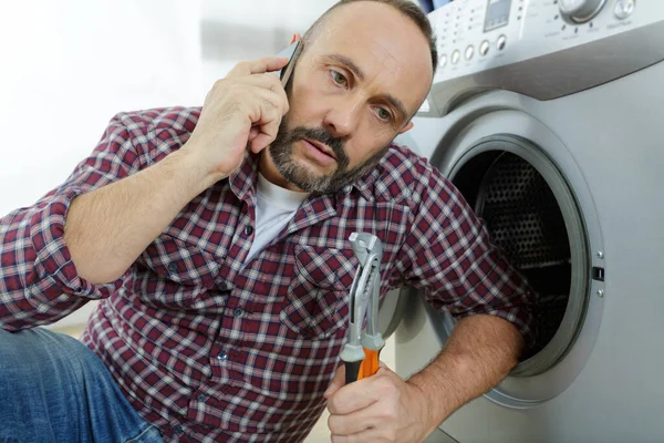 Hombre Teléfono Repara Una Lavadora —  Fotos de Stock