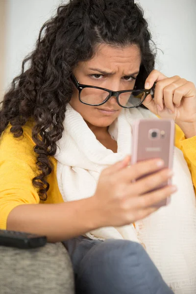 年轻而不确定的神经质女人看着智能手机 — 图库照片