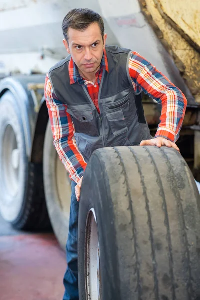 타이어를 굴리는 절뚝거리는 노동자들 — 스톡 사진