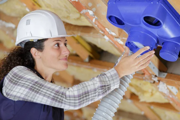 Female Electrician Installing Ventilation Pipese Ceiling — Stock Photo, Image