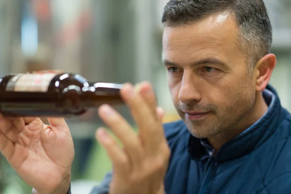 Trabajador Cervecero Inspeccionando Botella Cerveza — Foto de Stock