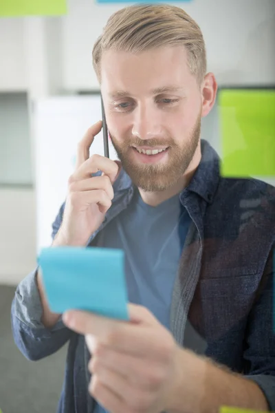 Man Making Telephone Call Reading Post Note Reminder — Stock Photo, Image