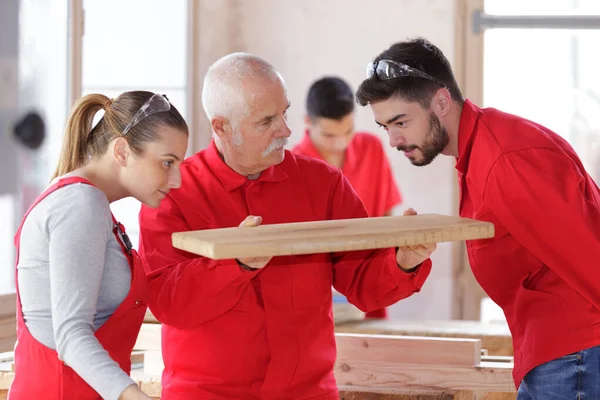 Carpinteiro Mostrando Aprendizes Uma Peça Madeira — Fotografia de Stock