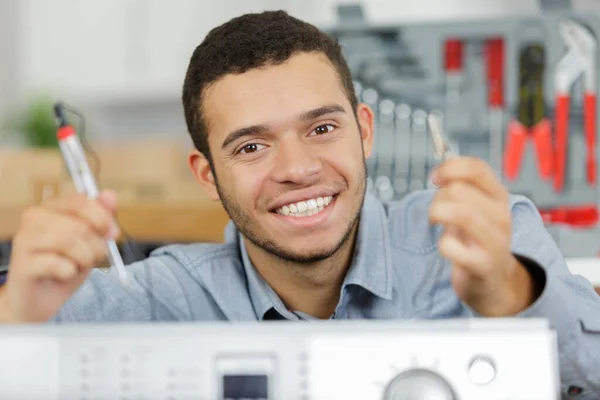 洗濯機を修理する幸せな技術者の肖像画です — ストック写真